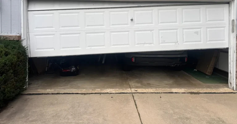 White sectional garage door visibly tilted and partially open at an Evanston home.
