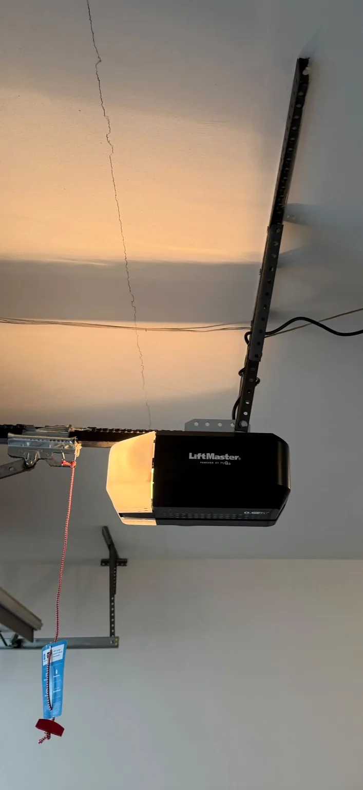 Ceiling-mounted LiftMaster Wi-Fi garage door opener with visible mounting rail and emergency release cord.