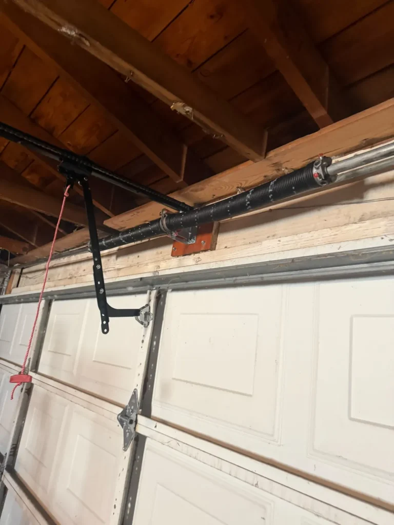 Garage door torsion springs mounted above a white sectional garage door in Skokie.